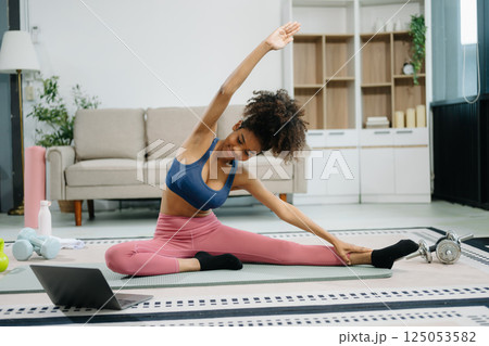A young woman practices yoga and stretching with a mat and gym props, showcasing wellness, motivation, A young woman practices yoga and stretching with a mat and gym props, showcasing wellness, motivation, 125053582