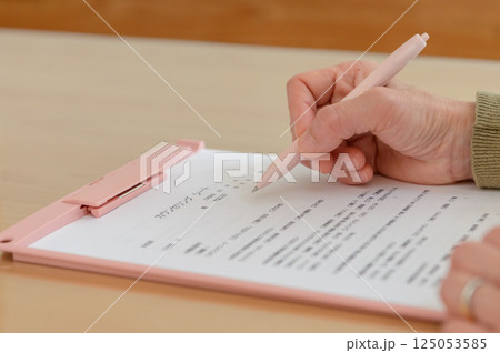 カウンセリングシートに書き込む女性の手元 カウンセリングシートに書き込む女性の手元 125053585