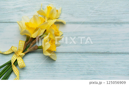 Bouquet of yellow daffodils lying on rustic wooden table 125056909