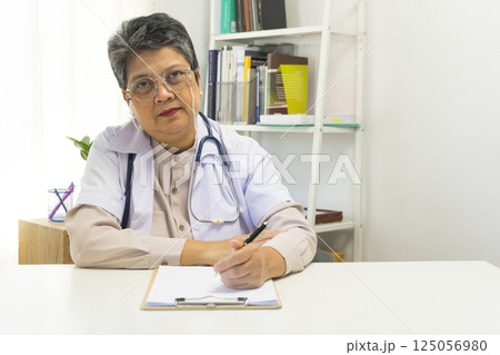 General practitioner taking notes when talking to female patient in hospital. General practitioner taking notes when talking to female patient in hospital. 125056980