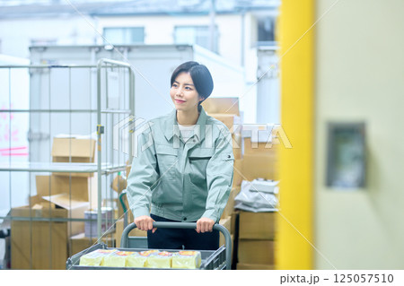 荷物を確認する作業着の女性ビジネスマン 荷物を確認する作業着の女性ビジネスマン 125057510