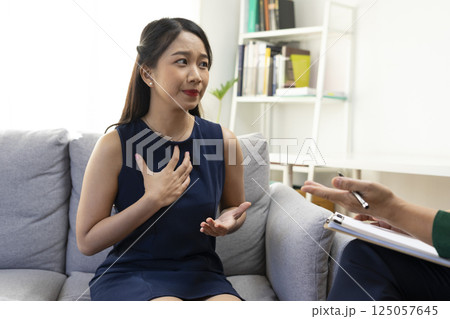 Asian psychologist doctor having session with young depressed woman in clinic. Psychology and mental therapy concept. 125057645