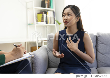 Asian psychologist doctor having session with young depressed woman in clinic. Psychology and mental therapy concept. Asian psychologist doctor having session with young depressed woman in clinic. Psychology and mental therapy concept. 125057646