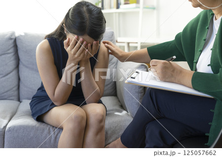 Asian psychologist doctor having session with young depressed woman in clinic. Psychology and mental therapy concept. Asian psychologist doctor having session with young depressed woman in clinic. Psychology and mental therapy concept. 125057662