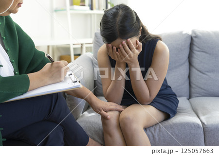 Asian psychologist doctor having session with young depressed woman in clinic. Psychology and mental therapy concept. Asian psychologist doctor having session with young depressed woman in clinic. Psychology and mental therapy concept. 125057663