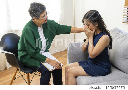 Asian psychologist doctor having session with young depressed woman in clinic. Psychology and mental therapy concept. Asian psychologist doctor having session with young depressed woman in clinic. Psychology and mental therapy concept. 125057676