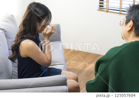 Asian psychologist doctor having session with young depressed woman in clinic. Psychology and mental therapy concept. Asian psychologist doctor having session with young depressed woman in clinic. Psychology and mental therapy concept. 125057684
