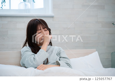 ベッドであくびをする女性 ベッドであくびをする女性 125057767