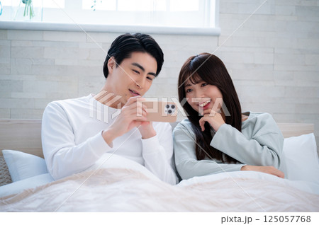 笑顔でスマホを見る男女 125057768