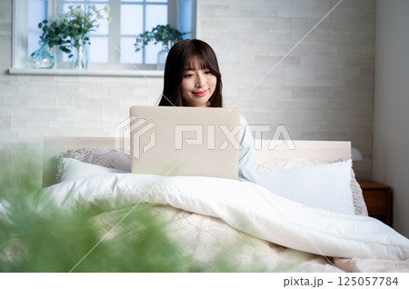 笑顔でパソコンを操作する女性 笑顔でパソコンを操作する女性 125057784