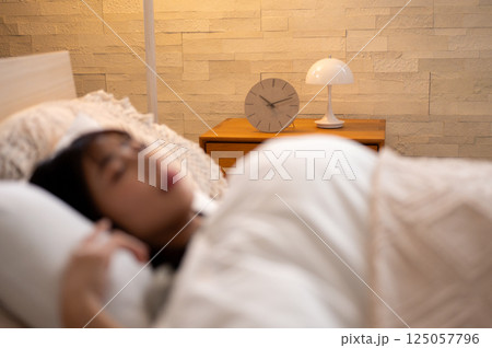 ベッドで眠る女性 125057796