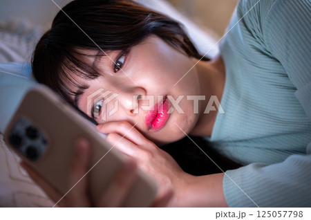 夜更かししてスマホを見る女性 夜更かししてスマホを見る女性 125057798