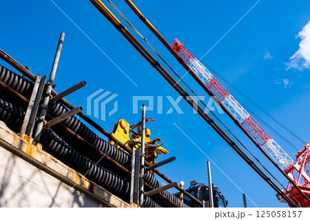 建設現場のクレーンと電線防護カバー　a-1 125058157