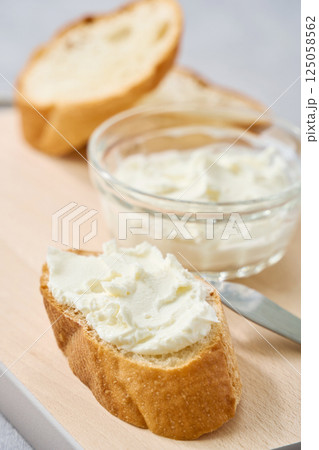 フランスパンに塗ったクリームチーズ 125058562