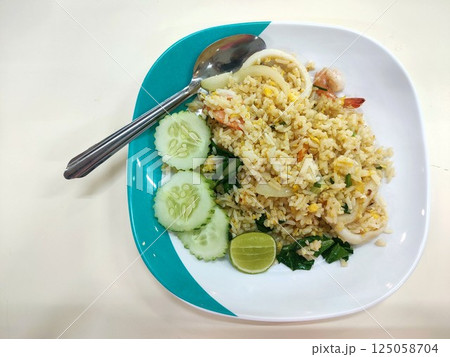 Seafood fried rice on a plate with a spoon Seafood fried rice on a plate with a spoon 125058704