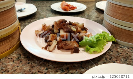 Fried pork from Trang Province, Thailand, placed on a plate on the dining table. 125058711