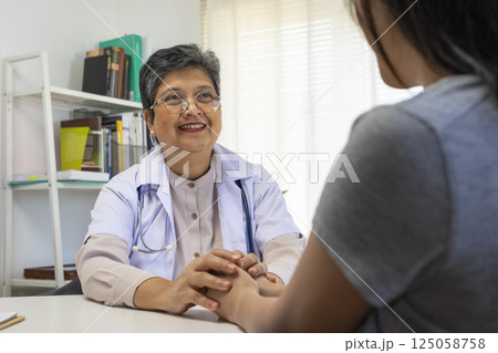 Patient writing personal info while listen to the senior doctor. 125058758
