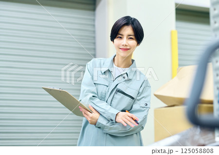 荷物を確認する作業着の女性ビジネスマン 荷物を確認する作業着の女性ビジネスマン 125058808