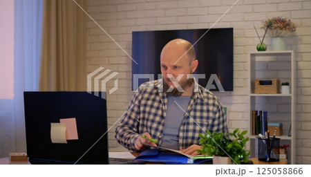 Man focusing on professional development at home, development evident in learning new skills, development key to career growth, development driving success, ideal for educational projects. 125058866