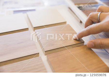 フローリングサンプルから色を選ぶ女性手元 家づくり打ち合わせ フローリングサンプルから色を選ぶ女性手元 家づくり打ち合わせ 125059076