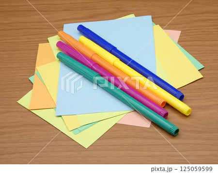 水性カラーペンと乱雑に置かれた色画用紙 125059599