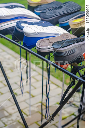 Multiple sneakers upside down on drying rack outdoors after cleaning and washing. High quality photo 125059603