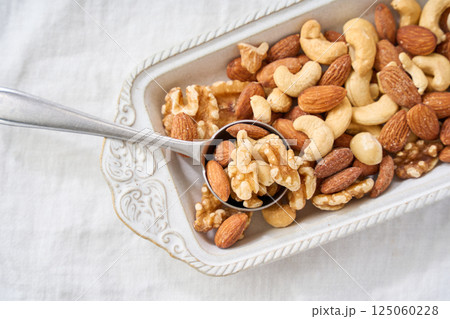 白い器に盛り付けたミックスナッツとスプーン 白い器に盛り付けたミックスナッツとスプーン 125060228