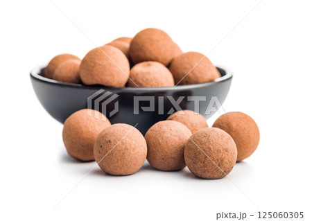 Chocolate truffles with cocoa powder and caramel filling  isolated on white background. 125060305