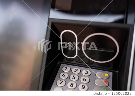 Close-up of a modern payment terminal with a keyboard and contactless payment function Close-up of a modern payment terminal with a keyboard and contactless payment function 125061025