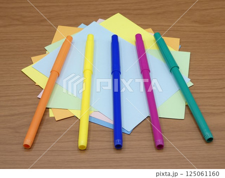 水性カラーペンと乱雑に置かれた色画用紙 水性カラーペンと乱雑に置かれた色画用紙 125061160