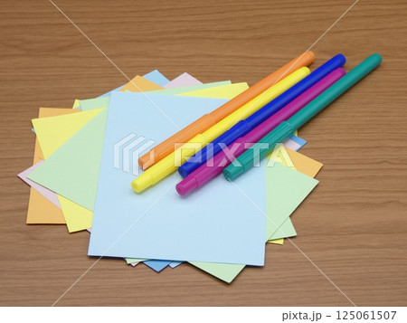 水性カラーペンと乱雑に置かれた色画用紙 水性カラーペンと乱雑に置かれた色画用紙 125061507
