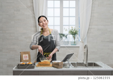 キッチンで米粉のパウンドケーキを作る女性 キッチンで米粉のパウンドケーキを作る女性 125061555