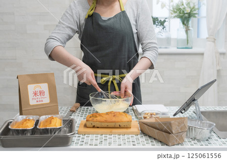 キッチンで米粉のパウンドケーキを作る女性 キッチンで米粉のパウンドケーキを作る女性 125061556