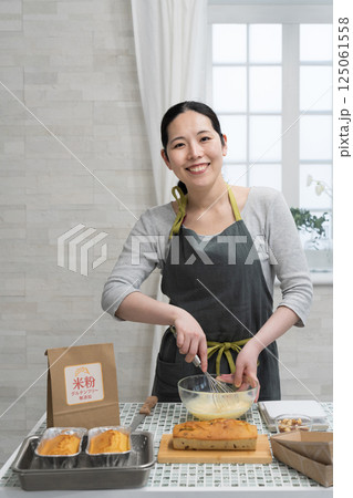 キッチンで米粉のパウンドケーキを作る女性 キッチンで米粉のパウンドケーキを作る女性 125061558