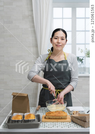 キッチンでパウンドケーキを作る女性 125061563