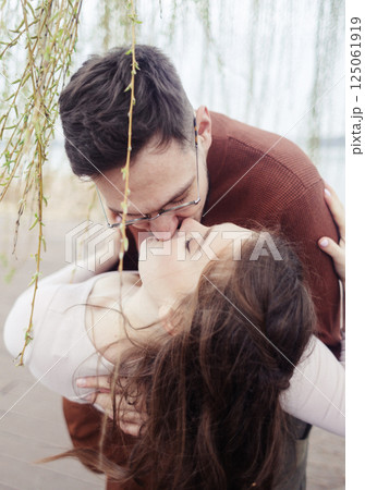 Young couple in stylish clothes on a walk. Romantic date outdoors. Walk, kisses and hugs Young couple in stylish clothes on a walk. Romantic date outdoors. Walk, kisses and hugs 125061919