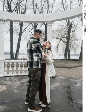 Young couple in stylish clothes on a walk. Romantic date outdoors. Walk, kisses and hugs 125061938