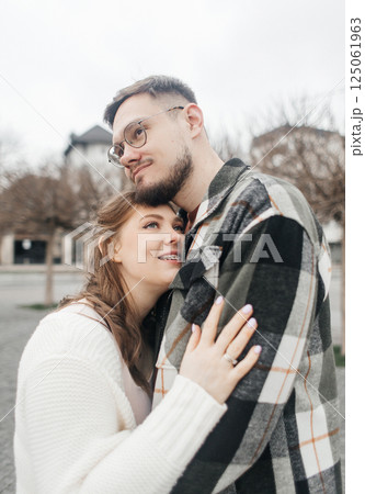 Young couple in stylish clothes on a walk. Romantic date outdoors. Walk, kisses and hugs Young couple in stylish clothes on a walk. Romantic date outdoors. Walk, kisses and hugs 125061963
