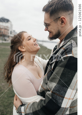 Young couple in stylish clothes on a walk. Romantic date outdoors. Walk, kisses and hugs Young couple in stylish clothes on a walk. Romantic date outdoors. Walk, kisses and hugs 125061986