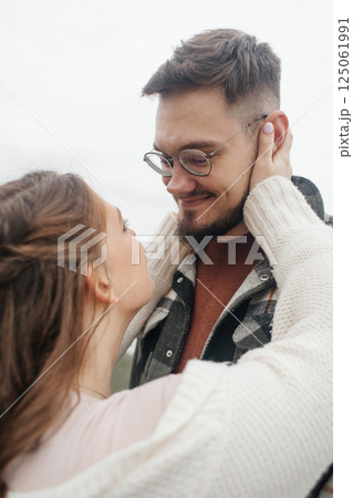 Young couple in stylish clothes on a walk. Romantic date outdoors. Walk, kisses and hugs 125061991