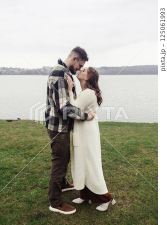 Young couple in stylish clothes on a walk. Romantic date outdoors. Walk, kisses and hugs 125061993