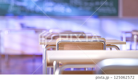 Empty classroom with wooden chairs and desks, blurred chalkboard in the background, back to school concept Empty classroom with wooden chairs and desks, blurred chalkboard in the background, back to school concept 125062572
