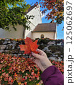 Fall Serenity, Young Woman with Maple Leaf Outside Swedish Church, Vertical 125062697