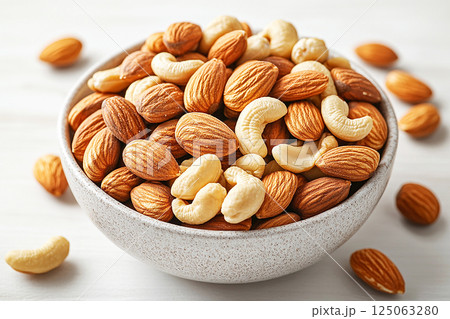 Bowl of mixed nuts on a white background. Almonds, walnuts and cashews, rich in magnesium and B vitamins. Healthy snacks. 125063280