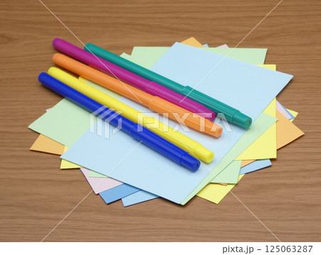 水性カラーペンと乱雑に置かれた色画用紙 125063287