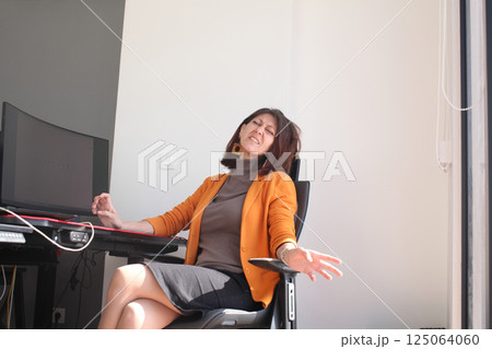 an adult woman in the office talking on phone call 125064060