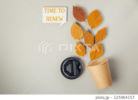 Coffee cup with a leaf on it and the words Time to Renew written above it Coffee cup with a leaf on it and the words Time to Renew written above it 125064157