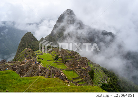 Panoramic view of Machu Picchu ruins surrounded by misty mountains, Peru 125064851