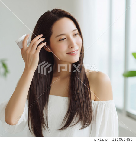 髪の毛のアウトバストリートメントを塗る女性 125065480