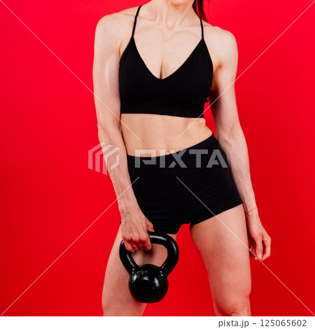 Fitness woman doing crossfit exercising with kettle bell with muscular fit and slim body. Fitness woman doing crossfit exercising with kettle bell with muscular fit and slim body. 125065602